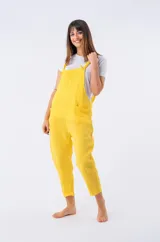 Enterito de lino color amarillo vibrante, con tirantes ajustables y bolsillos frontales. Corte holgado que llega hasta el tobillo.