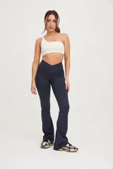 Top deportivo blanco de un solo hombro, con elástico en el contorno superior y sostén interno en el lado derecho.