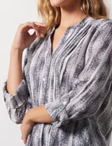 Blusa de gasa estampada multicolor, marca Ruby Rd. Tiene cuello a la base, escote en V, abertura central con botones y plisados en la parte delantera. Las mangas son 3/4 y tienen un largo regulable con presilla y botón.
