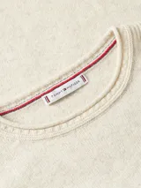 Sweater de lana de corte regular con cuello redondo y mangas largas. Presenta un diseño minimalista en color beige con el logo de la marca bordado en el pecho.