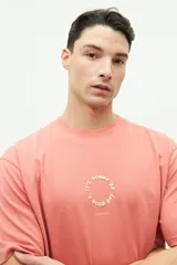 Remera de manga corta color salmón, con cuello redondo y corte regular. Presenta un estampado circular en relieve en el pecho con la frase 'It's gonna be a good day' y el logo de la marca Brooksfield.