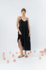 Vestido midi de corte amplio con breteles finos y escote en V. Confeccionado en gasa de algodón con textura, presenta un diseño escalonado con vuelo en el ruedo.