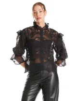 Blusa de tul bordado color negro, con cuello alto, cierre frontal con botones y mangas tres cuartos con terminación amplia.