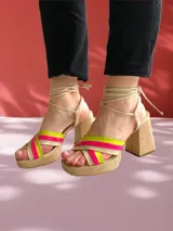 Sandalias color beige con plataforma y tacón cuadrado. Presentan tiras cruzadas en el empeine y tiras largas para atar alrededor del tobillo.