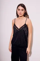Top negro con estampado animal print, breteles finos y detalles de encaje en escote y ruedo.