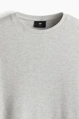 Remera de manga larga gris claro en tejido waffle de mezcla de algodón.