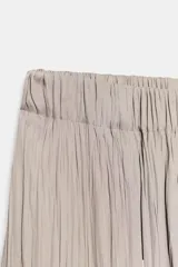 Pantalón de tiro medio con cintura elástica y bajo acabado en puño elástico. Presenta un diseño con tejido efecto arrugado y bolsillos laterales ocultos en costura.