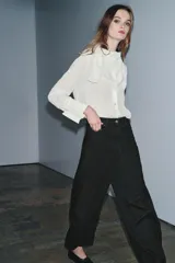 Jeans de tiro medio con corte balloon leg y largo al tobillo. Presenta diseño de cinco bolsillos, cintura con trabillas y cierre frontal con cremallera y botón metálico.