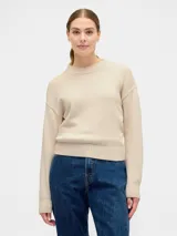 Buzo de tejido de punto color beige, con cuello redondo, mangas largas y puños acanalados.