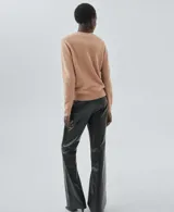 Jersey de cashmere color tostado, de tejido de punto fino, cuello redondo, diseño recto y manga larga con puño acanalado.