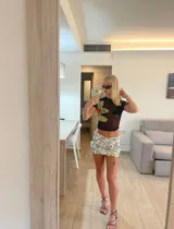 Top negro de microtul con estampado de orquídeas verdes.