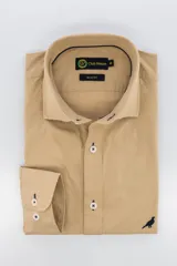 Camisa color beige de algodón poplin lavado, corte slim fit, manga larga, cuello clásico y cierre con botones.