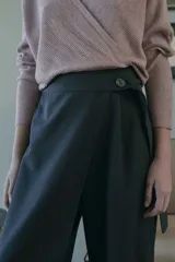 Pantalón de tiro medio, pierna ancha y diseño cruzado en la parte delantera con detalle de lazo y botón lateral.