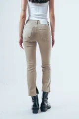 Jean de corte bootcut y tiro medio, color gris oscuro desgastado. Presenta un diseño de pierna recta que se ensancha ligeramente hacia el ruedo, con cierre frontal y bolsillos clásicos.