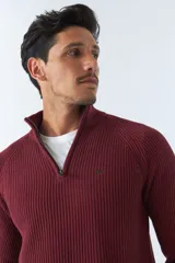 Sweater de tejido de punto acanalado en color negro, con cuello alto y cierre frontal parcial. Cuenta con mangas largas y un pequeño logo bordado en el ruedo.