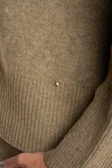 Sweater de punto color tostado con calce oversize, cuello redondo y mangas largas anchas. Presenta terminaciones acanaladas en cuello, puños y ruedo.