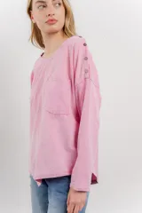 Remera manga larga color rosa con bolsillo en el pecho y corte irregular en el ruedo.