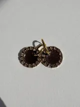 Aros colgantes dorados con dije circular de resina color turquesa, bordeado con strass. El arito es de acero quirúrgico.