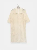 Camisa larga negra de punto calado con cuello camisero, manga tres cuartos y cierre frontal con botones.