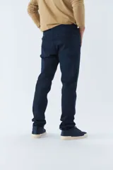 Pantalón de jean corte regular con tiro medio, diseño clásico de cinco bolsillos, cierre frontal con botón y bragueta, y trabillas para cinturón.