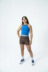 Musculosa deportiva de lycra color azul con cuello halter y ribetes marrones. Estampado con el logo de la marca en el pecho.