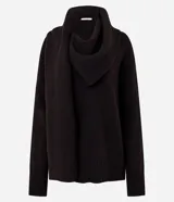 Suéter de punto color negro con fit holgado, mangas largas, cuello alto y bufanda integrada con caída frontal. Presenta puños y ruedo acanalados.