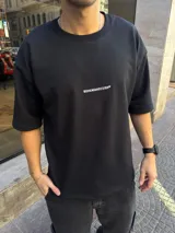 Remera de algodón pesado color negro, de corte oversize con mangas cortas y cuello redondo. Presenta un pequeño logo estampado en blanco en el centro del pecho.