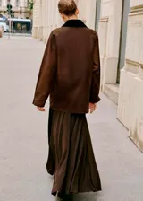 Parka color marrón con efecto encerado, diseño recto y manga larga. Cuenta con cuello camisero de pana, cierre frontal de cremallera y botones a presión, múltiples bolsillos de parche con solapa y forro interior.