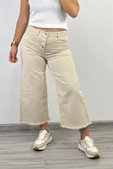 Pantalón culotte color beige con tiro alto, corte ancho, largo a media pierna y terminación desflecada.
