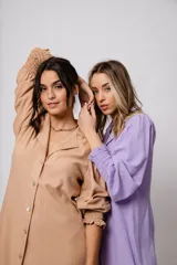 Vestido corto color tostado, con cuello solapa, abotonado al frente y mangas 3/4 con puños fruncidos.