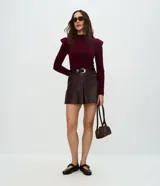 Short de tiro medio confeccionado en poliuretano con acabado que imita el cuero, de corte recto y diseño minimalista. Incluye un cinturón ajustable con hebilla metálica.