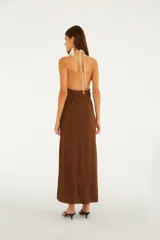 Vestido largo marrón con escote halter y espalda descubierta, confeccionado en tejido ligero con intrincados bordados en color crudo con motivos florales.