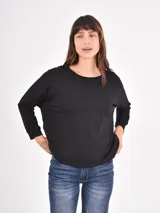 Remera de manga larga color negro, con cuello redondo y puños elásticos, de corte holgado.