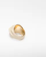 Anillo de metal con relieve y acabado lacado en color beige, de diseño voluminoso e irregular con interior dorado y logo grabado.