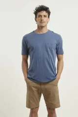 Remera gris con bolsillo ojal en el pecho, de manga corta y cuello redondo.