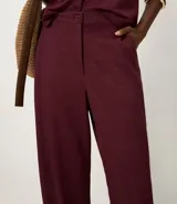 Pantalón de corte recto color bordó, confeccionado en tejido Orly con fondo melange. Presenta cintura con elástico en la parte posterior y cierre tradicional frontal.