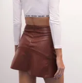 Minifalda marrón de ecocuero, de tiro medio y corte evasé.