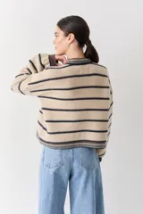 Cardigan de punto color bordó con cuello redondo, cierre frontal de botones y detalles de ribetes en contraste en cuello, puños y ruedo. Presenta un pequeño bordado de una raqueta de tenis en el pecho.