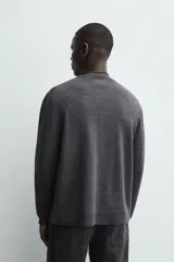 Cárdigan de punto con lana, de corte regular fit, cuello redondo y manga larga. Presenta cierre frontal con botones y acabados en rib en puños y bajo.