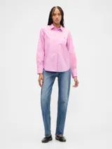 Camisa de manga larga color celeste, con cuello clásico, cierre frontal de botones, bolsillo en el pecho con detalle bordado y dobladillo redondeado.