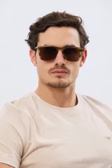 Lentes de sol polarizados con armazón marrón translúcido y diseño cuadrado.