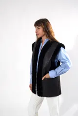 Chaleco de napalan negro, diseño reversible, sin mangas, con corte recto y bolsillos laterales.