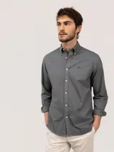 Camisa de hombre de corte regular fit, color gris oscuro, confeccionada en algodón con acabado vintage de tintado en prenda. Cuenta con cuello button-down, cierre frontal de botones, manga larga y logo bordado en el pecho.