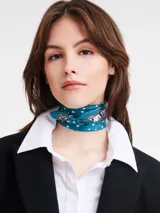 Pañuelo de seda azul con estampado de estrellas blancas y motivos de la Torre Eiffel en tonos marrones y rojos.