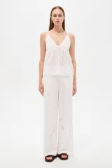 Musculosa blanca de algodón con diseño de broderie, escote en V, tirantes finos regulables y corte holgado.