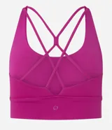 Top deportivo alargado color fucsia, con escote en U y cintura ancha. Posee tiras finas cruzadas en la espalda y copas removibles.