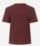 Blusa de manga corta confeccionada en tejido acanalado de algodón con elastano, de color bordó con cuello polo en tono amarillo claro y escote en V.