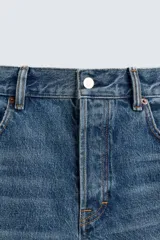 Jeans de mezclilla de algodón, tiro medio, con pierna recta y ajuste ligeramente holgado. Presenta efecto lavado y cierre frontal de botonadura.