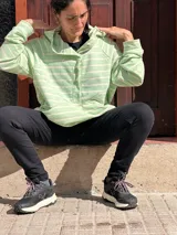 Canguro oversize de rústico de algodón con diseño a rayas horizontales en color verde menta y blanco. Presenta capucha, escote con broches frontales, bolsillo tipo canguro al frente y puños elásticos en mangas y ruedo.