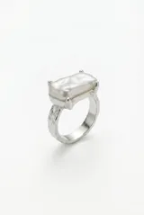 Anillo de metal plateado con textura irregular y perla barroca rectangular engastada en el centro.